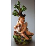 A DERBY PORCELAIN CUPID SEATED WITH A DOG in enamelled colours. Incised No. 213. 5ins high. See