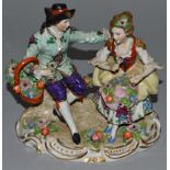 A SITZENDORF PORCELAIN GROUP OF YOUNG LOVERS seated on tree stumps and encrusted with figures.