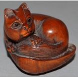 A CARVED WOOD NETSUKE, a cat on a clam. Signed.