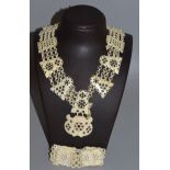 A CARVED AND PIERCED IVORY NECKLACE AND BRACELET.