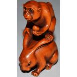 A BOXWOOD CARVED NETSUKE, A MONKEY ON A RABBIT’S BACK, signed.