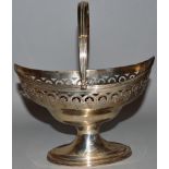 A GEORGE III BOAT SHAPED PIERCED PEDESTAL SUGAR BASIN with reeded edge and swing handle. London