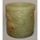 A CHINESE CELADON-GREEN JADE-LIKE BRUSH POT, the sides decorated in relief with a continuous river