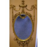 A VERY GOOD ADAM DESIGN OVAL GILT MIRROR with urn finial, ribbon motifs and garlands. Overall