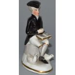 A DERBY PORCELAIN FIGURE, DR SYNTAX READING, in coloured enamels, sitting cross legged, two ducks at