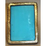 AN UPRIGHT EASEL PHOTOGRAPH FRAME with bead edge. 6.5ins high x 4.5ins wide. Birmingham 1924.