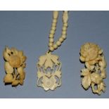 A CARVED IVORY NECKLACE AND PENDANT AND TWO BROOCHES.