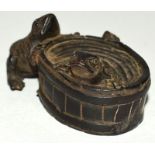 A CARVED WOOD NETSUKE, two frogs on a barrel.