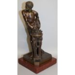 A SUPERB BRONZE OF A YOUNG CLASSICAL MAN standing beside a brazier, 13ins high, on a marble base.