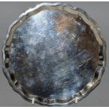 A CIRCULAR SILVER PIE CRUST SALVER, 7.5ins diameter, supported on three curving feet. Sheffield