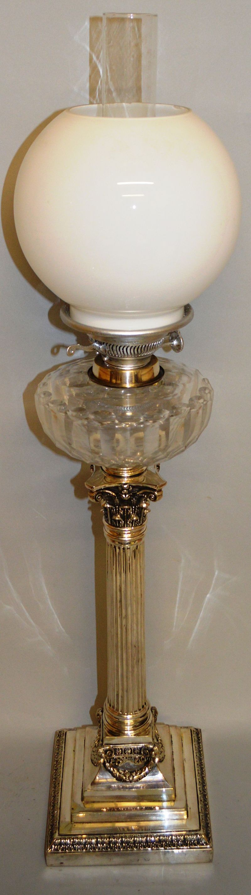 A VERY GOOD PLATE CORINTHIAN COLUMN OIL LAMP with glass reservoir and globe.