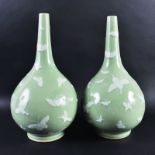 A PAIR OF CHINESE CELADON PORCELAIN VASES, of bulbous form, decorated in white enamelling with