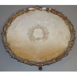 A GOOD GEORGE III CIRCULAR SALVER with engraved cartouche shell and gadrooned border on four claw