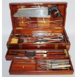 A FULL SURGEONS KIT IN A FITTED WOODEN BOX, belonging to Sydney W. Thompstone F.R.C.S.E., in a brass