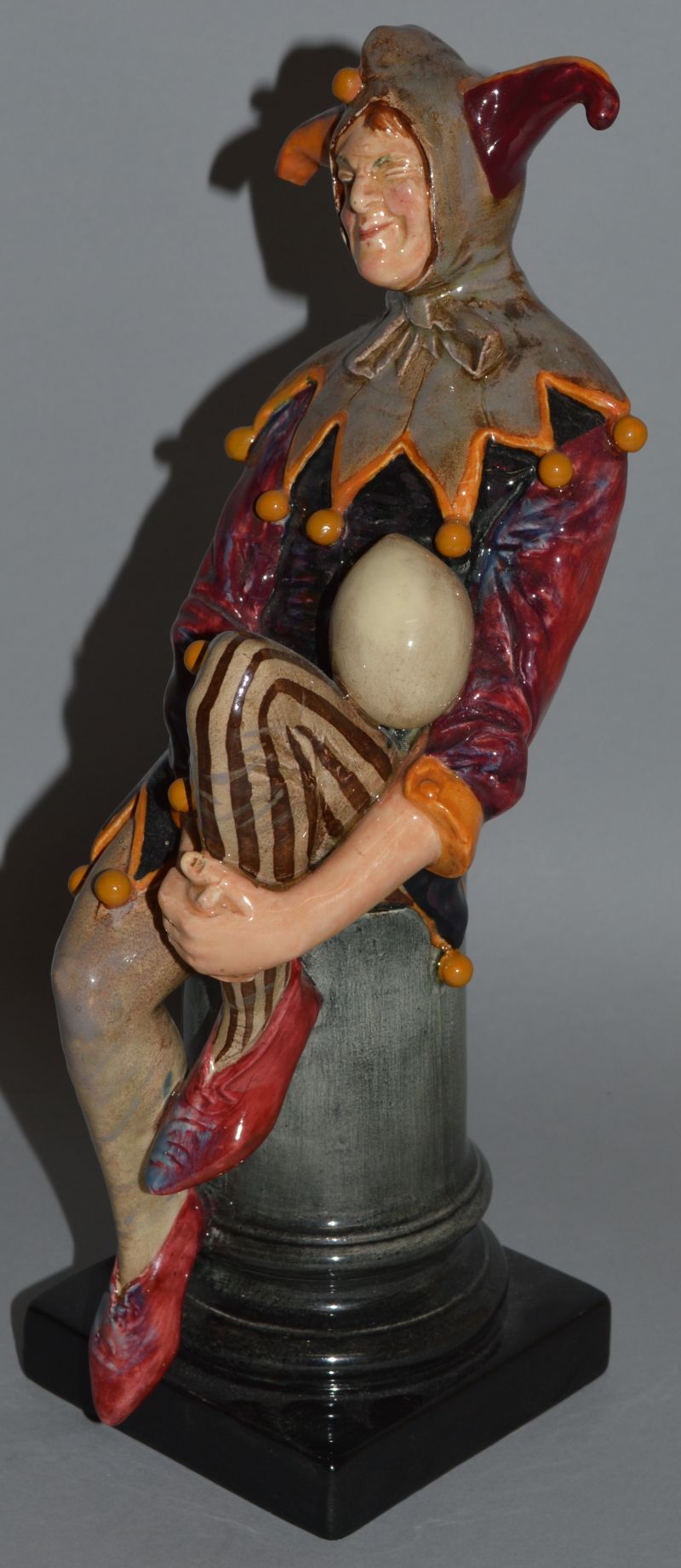 A ROYAL DOULTON FIGURE “THE JESTER”, HN1702. 10.5ins high. Piece missing off hat.