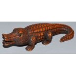 A CARVED WOOD NETSUKE, an alligator. Signed.