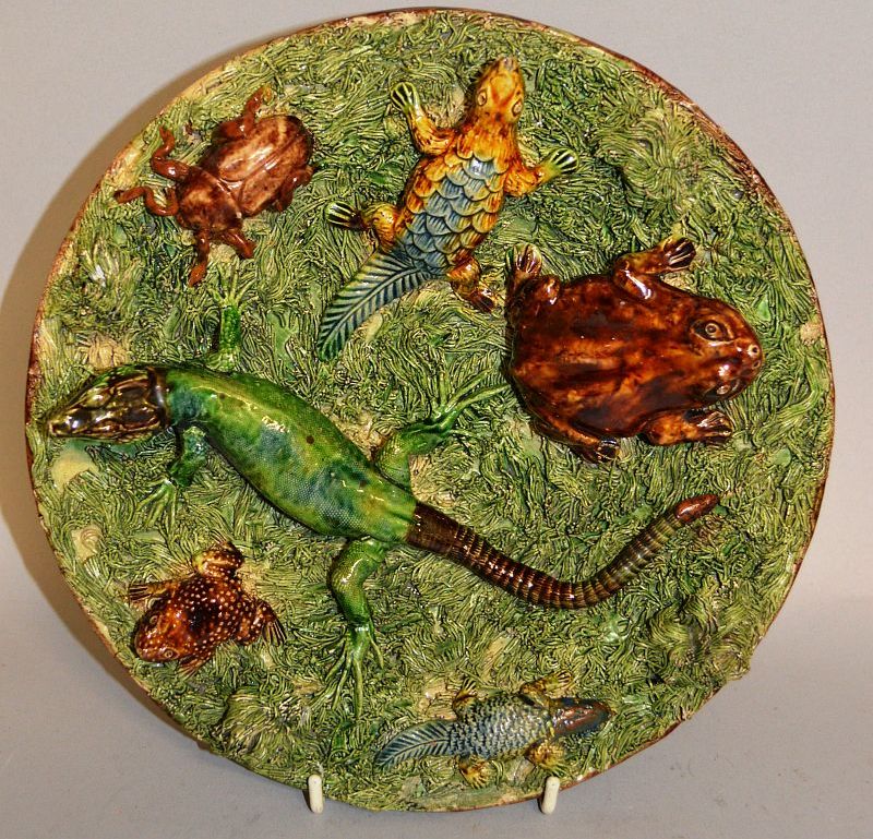 A PORTUGUESE BROWN GLAZED STONEWARE CIRCULAR DISH with reptiles and insects in relief. 9ins