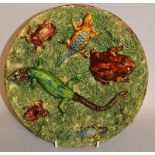 A PORTUGUESE BROWN GLAZED STONEWARE CIRCULAR DISH with reptiles and insects in relief. 9ins