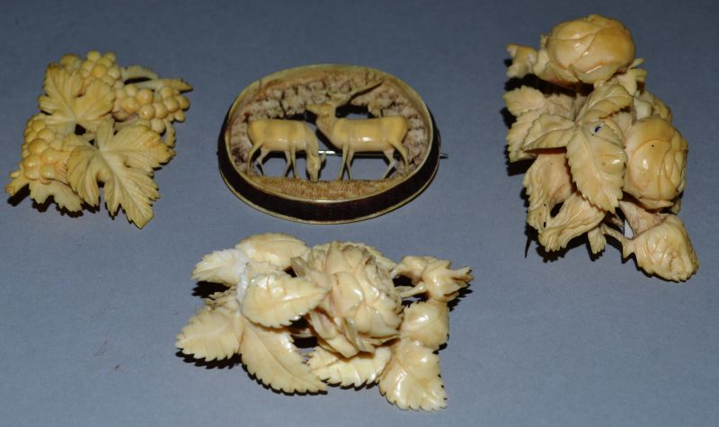 FOUR CARVED IVORY BROOCHES.