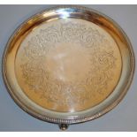 A VICTORIAN CIRCULAR SALVER with engraved body and reeded edge on three curving feet. 9.75ins