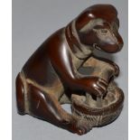 A CARVED WOOD NETSUKE, a bear with a basket of fruit.