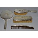 A JENSEN FOUR PIECE SILVER DRESSING TABLE SET comprising hand mirror, two brushes and comb.