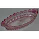 AN OVAL RUBY TINTED DISH with hobnail cutting and star base.