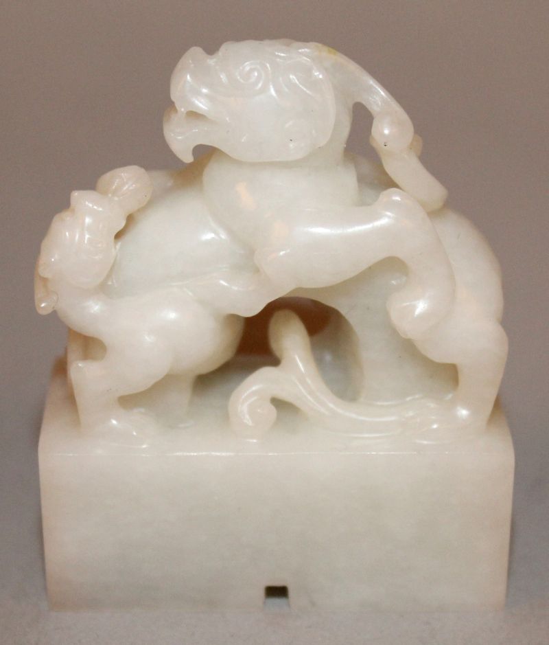 A SMALL CHINESE WHITE JADE-LIKE SEAL, in the form of two battling chilong, the base 1.6in x 0.75in &