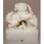 A SMALL CHINESE WHITE JADE-LIKE SEAL, in the form of two battling chilong, the base 1.6in x 0.75in &