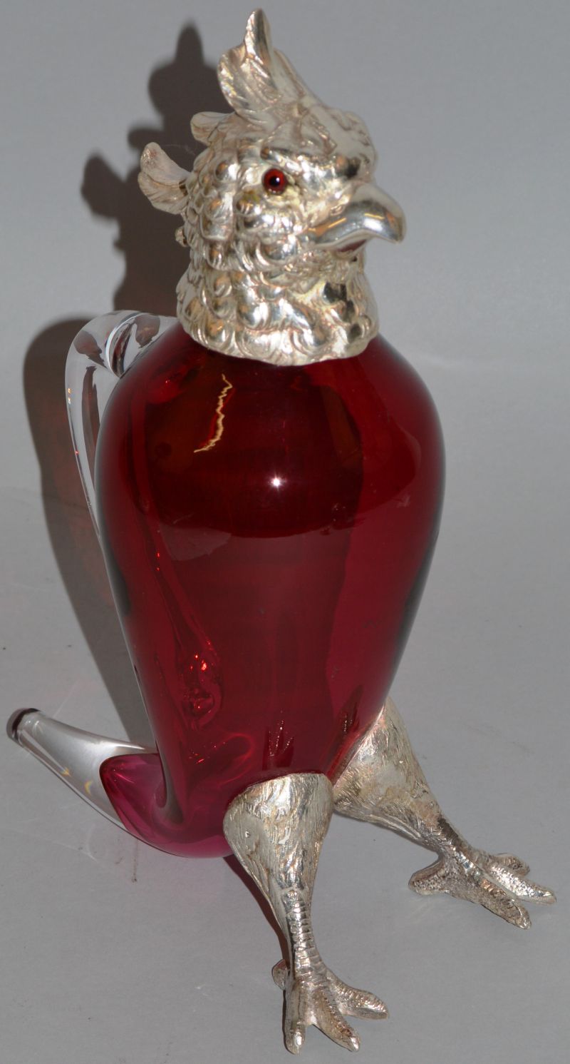 A GOOD PARROT RUBY GLASS CLARET JUG with plated head, glass eyes and feet. 10.5ins high.