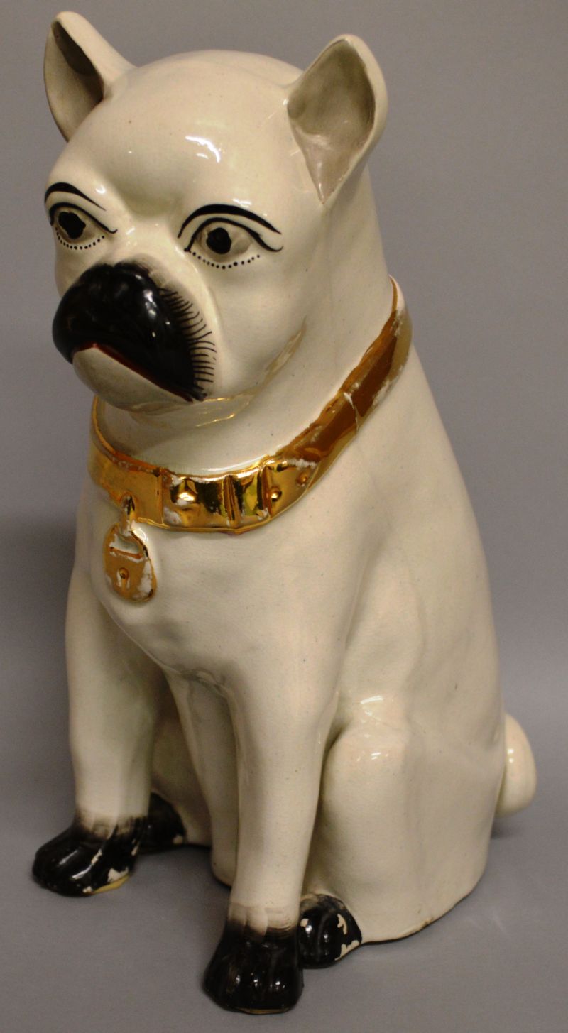 A LARGE STAFFORDSHIRE SEATED PUG DOG with gilt collar with lock, black eyes, nose and feet. 11.
