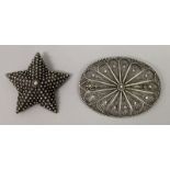AN EASTERN SILVER-METAL FILIGREE OVAL BROOCH, 2.75in x 2.1in; together with a star-form brooch