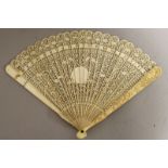 ANOTHER 19TH CENTURY CHINESE CANTON IVORY FAN, with twenty thin pierced and carved inner sticks, the