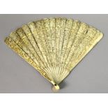 A 19TH CENTURY CHINESE CANTON IVORY FAN, with twenty-one thin inner sticks and two deeply carved