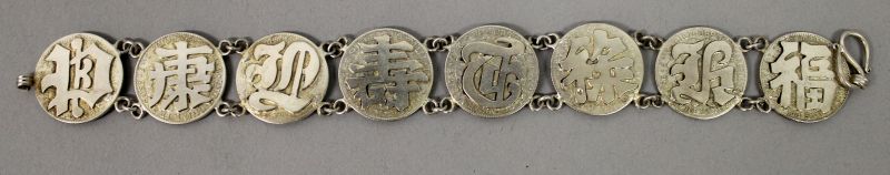 AN UNUSUAL SILVER-METAL BRACELET, in the form of dimes onlaid with auspicious Chinese characters,