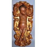 AN 18TH/19TH CENTURY CARVED, PAINTED AND GILDED FIGURE OF A CHERUB, arms enclosed in scrolling