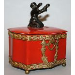 A RUSSIAN PORCELAIN SERPENTINE SIDED BOX AND COVER, the lid with a bronze figure 5.5ins wide.