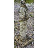 A RECONSTITUTED STONE GARDEN ORNAMENT modelled as a girl seated on a column. 2ft 9ins high.