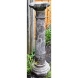 A GRANITE CIRCULAR COLUMN with fluted, stepped base. 3ft 9ins high.