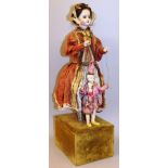 AN UNUSUAL FRENCH STANDING AUTOMATON PORCELAIN DOLL modelled in a period dress holding a bisque