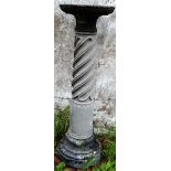 A RECONSTITUTED STONE PEDESTAL COLUMN with wrythen fluted decoration. 3ft 8ins high.