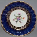 AN 18TH CENTURY WORCESTER WET BLUE PLATE painted with a flower centre surrounded by elaborate