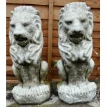 A PAIR OF RECONSTITUTED STONE FINIALS MODELLED AS LIONS RAMPANT. 1ft 8ins high.