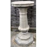 A RECONSTITUTED STONE BIRD BATH of Gothic octagonal form. 3ft 3ins high.