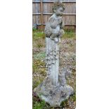 A RECONSTITUTED STONE GARDEN ORNAMENT modelled as Pan seated on a column. 2ft 9ins high.