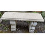 A RECONSTITUTED STONE BENCH on shaped supports. 3ft 3ins long.