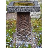 A RECONSTITUTED STONE CELTIC STYLE BIRD BATH on square pedestal base. 1ft 10ins high.