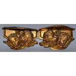 A SMALL PAIR OF CARVED AND GILDED FLORENTINE WINGED CUPID BRACKETS 9ins wide.