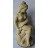 A RECONSTITUTED STONE FIGURE OF A SEATED FEMALE NUDE. 2ft 0ins high.