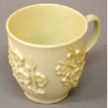 AN 18TH CENTURY BOW COFFEE CUP in Chinese blanc di chine style with moulded prunus decoration.
